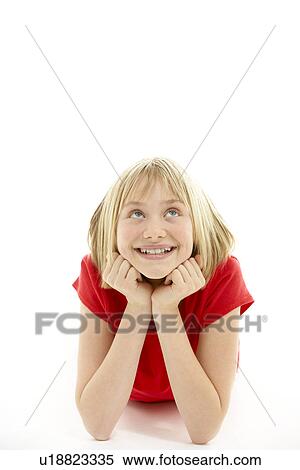 Stock Photography - Young Girl Lying On Stomach In Studio. Fotosearch