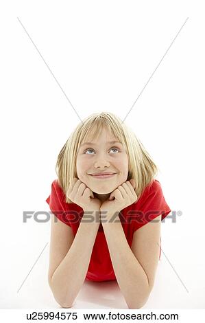 Stock Photography - Young Girl Lying On Stomach In Studio. Fotosearch