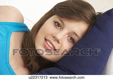 Stock Image - Young Girl Relaxing On Sofa. Fotosearch