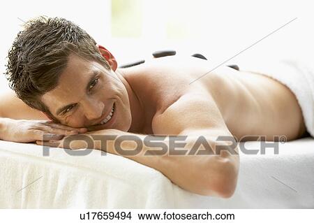 Young Man Enjoying Hot Stone Treatment View Large Photo Image Picture - Young Man Enjoying Hot Stone Treatment. Fotosearch