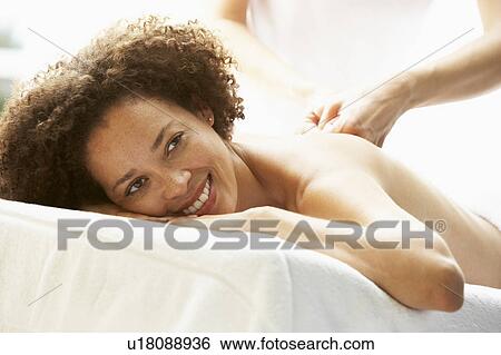 Stock Photograph - Young Woman Enjoying Hot Stone Treatment. Fotosearch