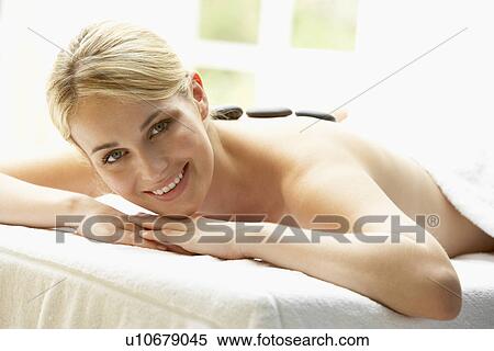 Stock Photography - Young Woman Enjoying Hot Stone Treatment. Fotosearch