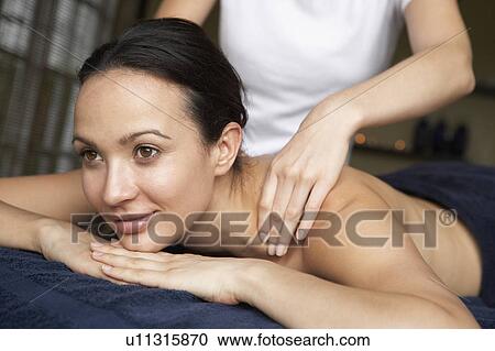 Stock Image - Young Woman Enjoying Massage. Fotosearch
