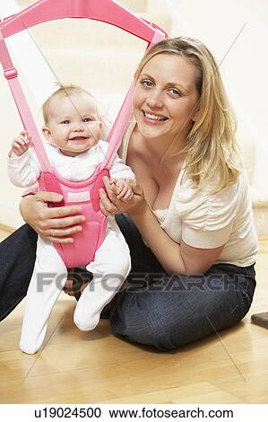 Stock Image - Baby In Bouncer With Mother. Fotosearch