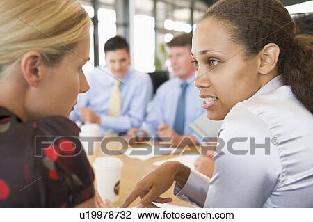 Businesswomen Talking To Each Other During Meeting View Large Photo Image Stock Image - Businesswomen Talking To Each Other During Meeting. Fotosearch