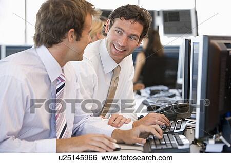 Stock Photograph - Colleagues Working Together At Computer. Fotosearch