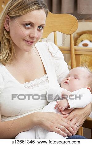 Stock Photograph - Mother Holding Baby In Nursery. Fotosearch