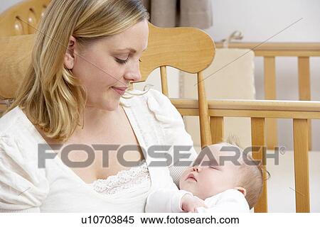 Stock Photography - Mother Holding Baby In Nursery. Fotosearch
