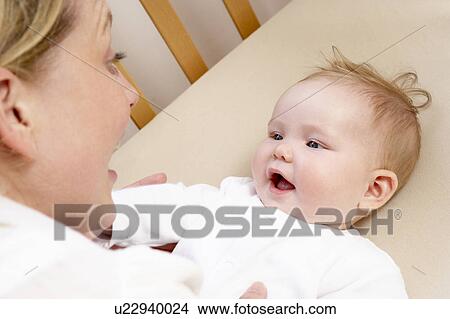 Picture - Mother Playing With Baby In Cot. Fotosearch