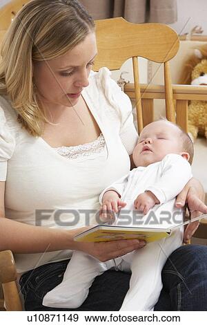 Stock Photo - Mother Reading Story To Baby In Nursery. Fotosearch