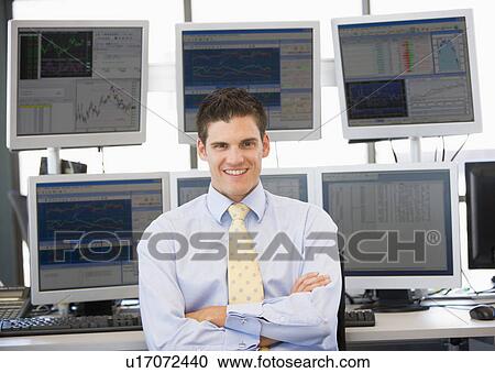 Stock Image - Portrait Of Stock Trader In Front Of Computer Monitors. Fotosearch