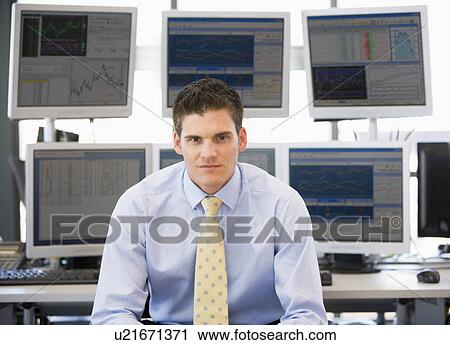 Stock Image - Portrait Of Stock Trader In Front Of Computer Monitors. Fotosearch