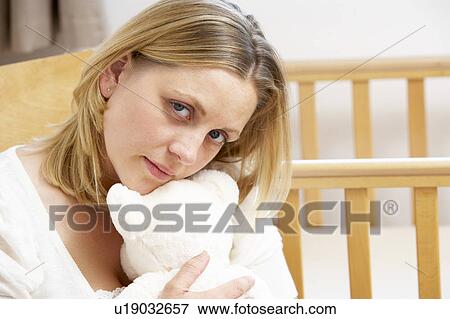 Stock Photo - Sad Mother Sitting In Empty Nursery. Fotosearch