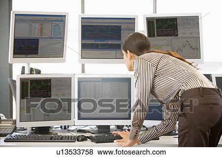 Stock Photo - Stock Trader Examining Computer Monitors. Fotosearch