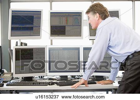 Stock Photo - Stock Trader Examining Computer Monitors. Fotosearch