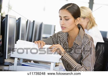 Stock Photo - Stock Trader Going Through Paperwork. Fotosearch