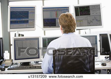 Stock Trader Looking At Multiple Monitors Stock Photo U13157209