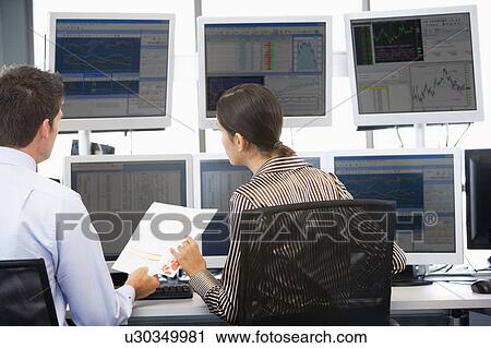 Stock Image - Stock Traders Viewing Monitors. Fotosearch