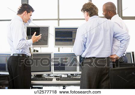 Stock Photo - Stock Traders Viewing Monitors. Fotosearch