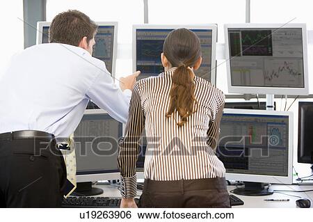 Stock Photograph - Stock Traders Viewing Monitors. Fotosearch