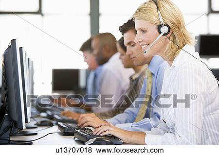 Stock Photo - Stock Traders With Headsets At Work. Fotosearch