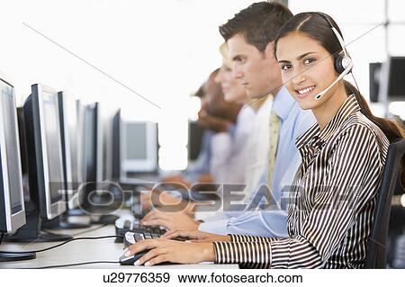 Stock Photo - Stock Traders With Headsets At Work. Fotosearch