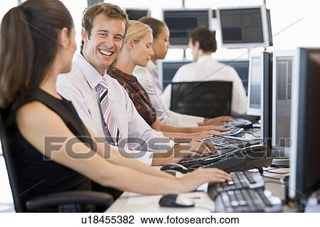 Stock Image - Stock Traders Working At Computers. Fotosearch