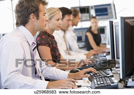 Stock Image - Stock Traders Working At Computers. Fotosearch