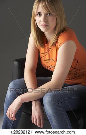 Stock Photo - Studio Portrait Of Teenage Girl Sitting In Chair. Fotosearch