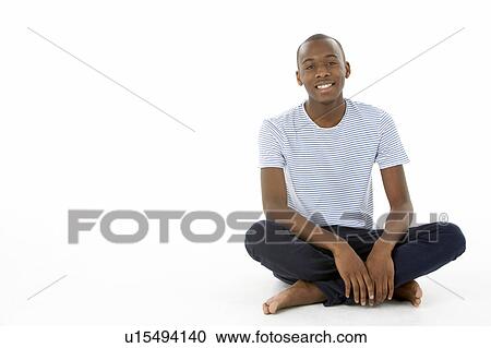 Stock Image - Teenage Boy Sitting In Studio. Fotosearch