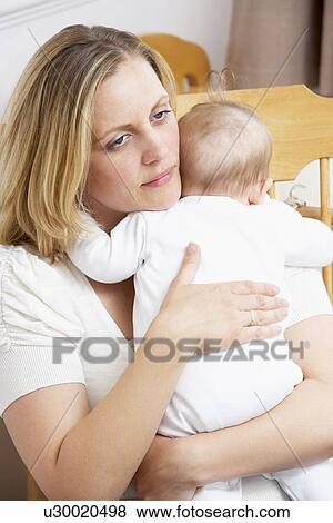 Stock Photo - Worried Mother Holding Baby In Nursery. Fotosearch