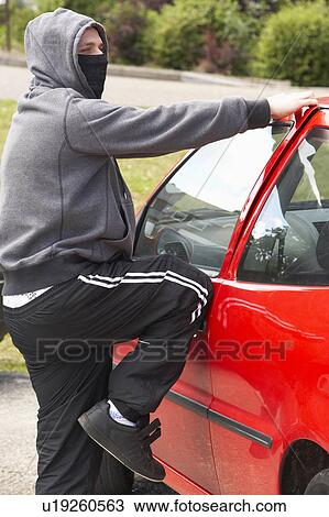 Stock Image - Young Man Breaking Into Car. Fotosearch