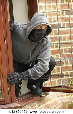 Stock Photograph - Young Man Breaking Into House. Fotosearch