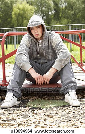 Picture - Young Man Sitting In Playground. Fotosearch