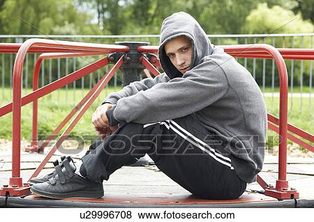 Stock Photo - Young Man Sitting In Playground. Fotosearch