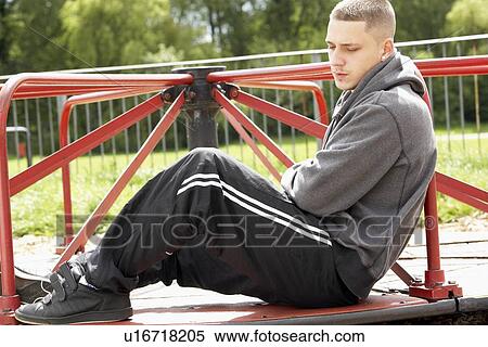 Stock Photography - Young Man Sitting In Playground. Fotosearch