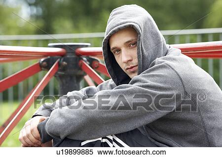 Stock Photography - Young Man Sitting In Playground. Fotosearch