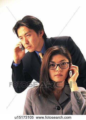 Stock Photography - Businessman and businesswoman using mobile phone, Front View. Fotosearch
