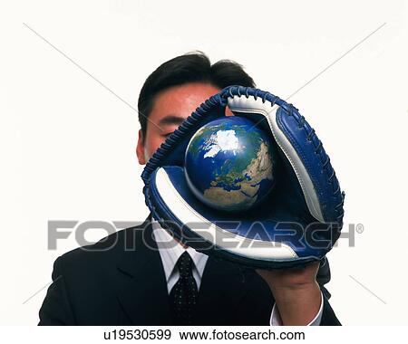 Stock Photo - Businessman grabbing a globe with glove, Close Up, Front View. Fotosearch
