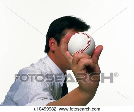 Stock Image - Businessman holding a baseball, Side View. Fotosearch