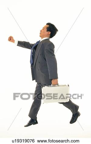 Stock Photograph - Businessman jumping with stretched fist, Side View. Fotosearch