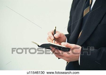 Businessman making note on scheduler, Side View View Large Photo Image Stock Image - Businessman making note on scheduler, Side View. Fotosearch