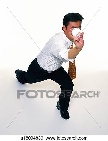 Stock Photo - Businessman pitching a baseball, High Angle View. Fotosearch