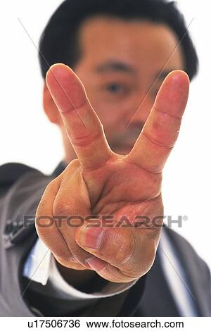 Stock Photograph - Businessman putting V sign up in the air, Close Up, Pin Focus. Fotosearch