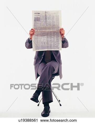 Stock Image - Businessman reading news paper, Front View. Fotosearch