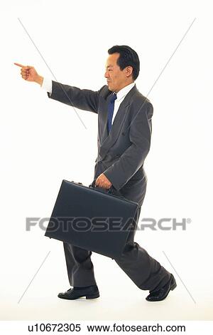 Stock Photography - Businessman with finger pointing at something, Side View. Fotosearch