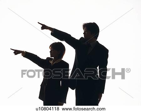 Stock Photo - Bsinessman and businesswoman both pointing away with fingers, Silhouette . Fotosearch