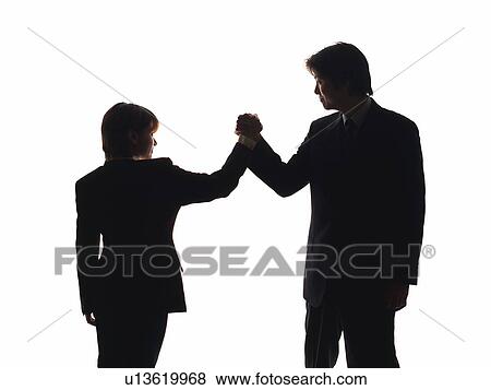 Stock Photo - Bsinessman and businesswoman shaking hands and committing, Side View, Silhouette . Fotosearch