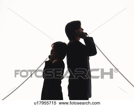 Stock Photography - Bsinessman and businesswoman standing back to back and talking on the phone, Side View, Silhouette . Fotosearch