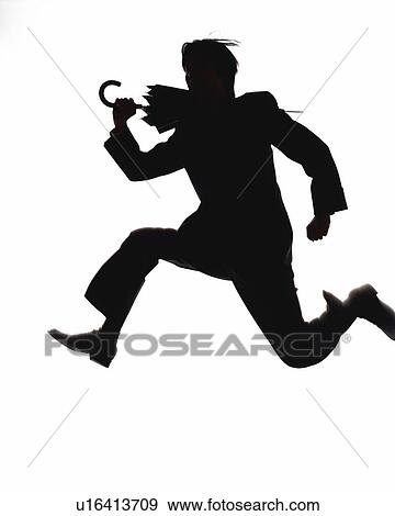 Stock Photo - Bsinessman jumping and running with folded umbrella, Side View, Silhouette . Fotosearch